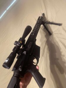 Scoped rifle with bipod on display