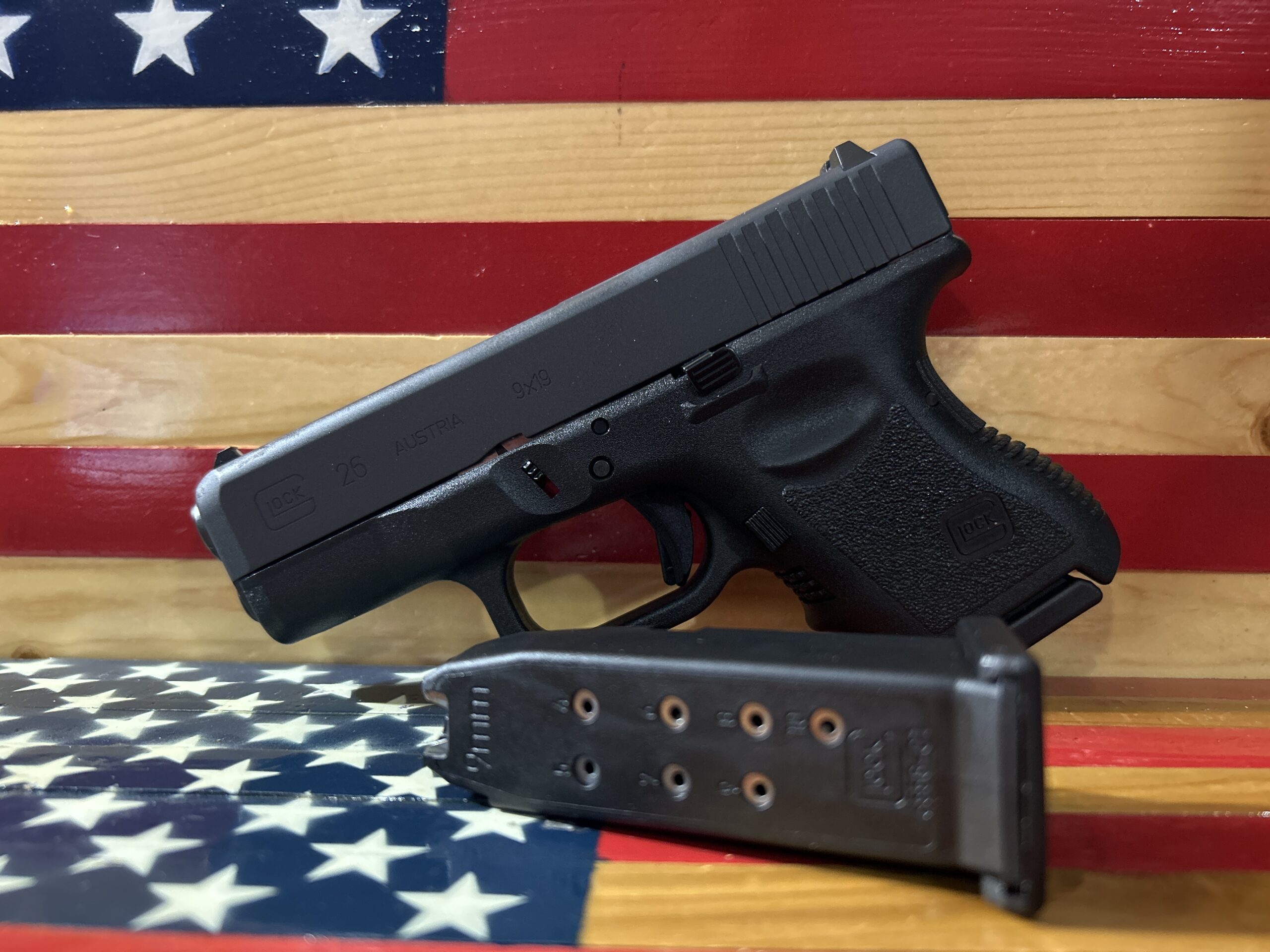 Handgun and magazine on American flag background.