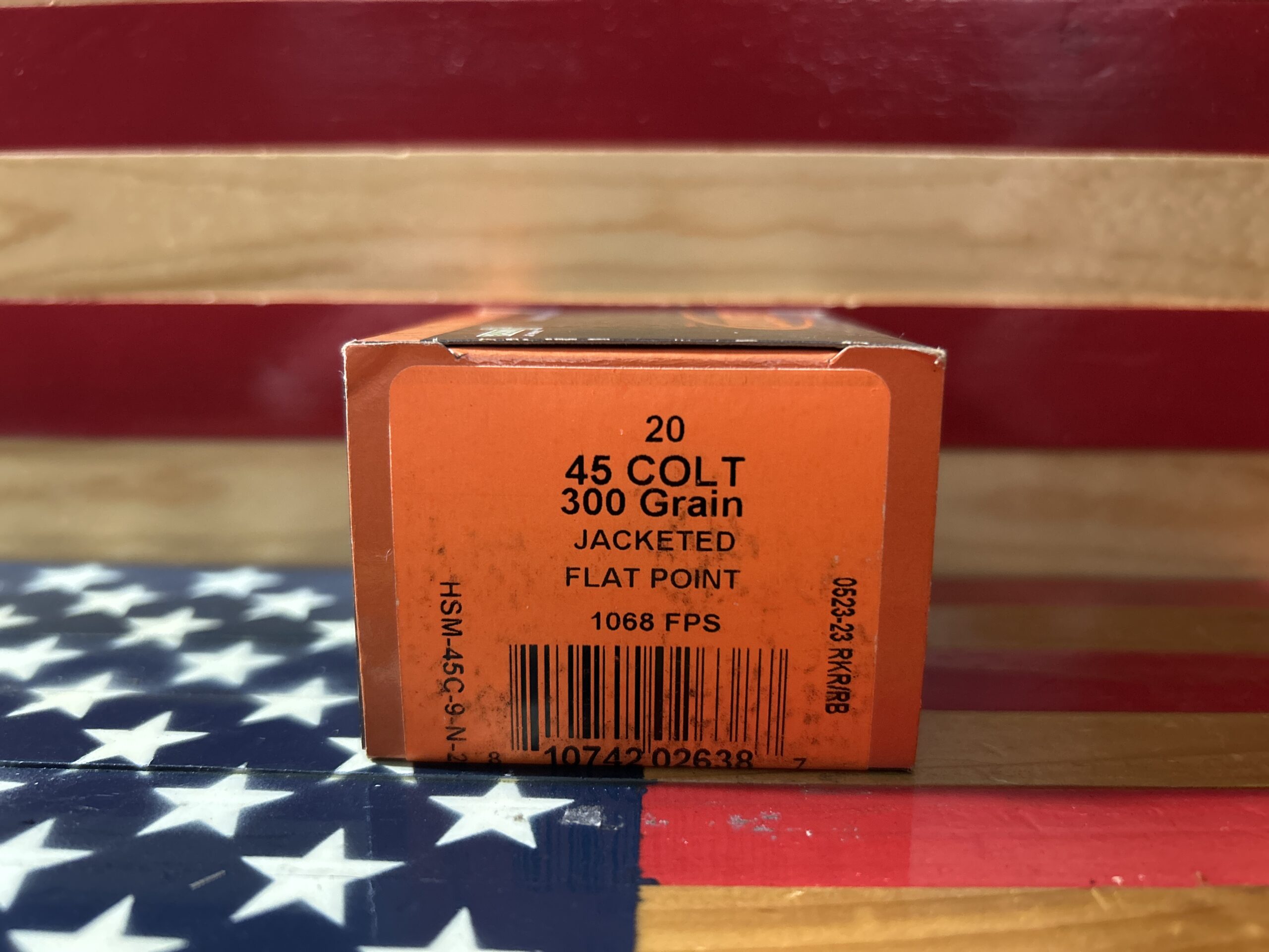 45 Colt ammunition box on American flag background.
