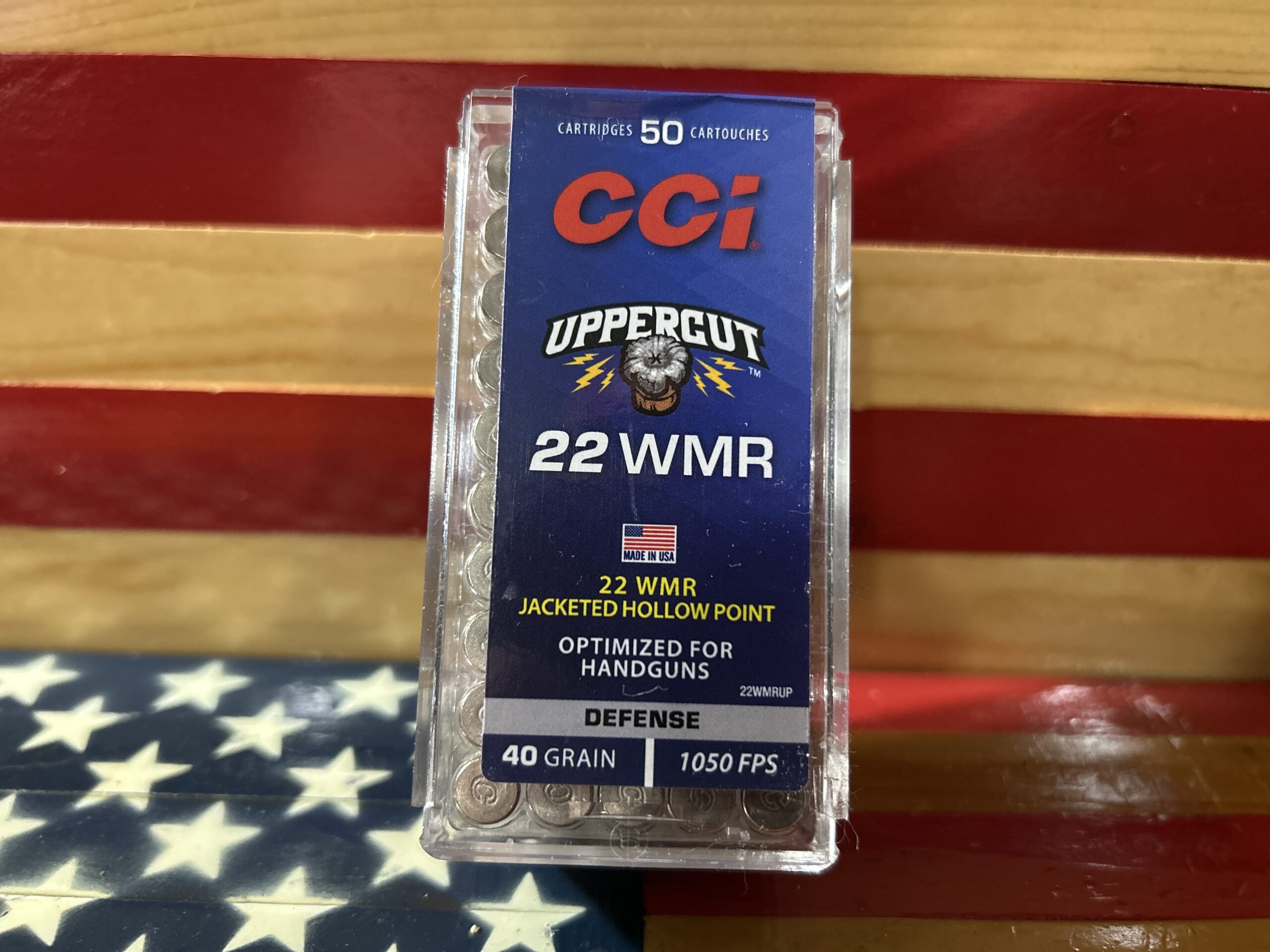 CCI 22 WMR handgun ammunition box on wooden background.