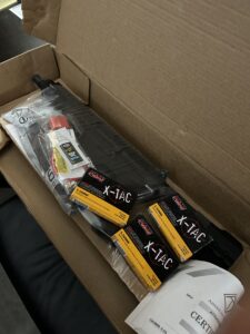 Cardboard box with gun accessories and manual.